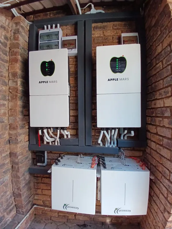 Two Apple Mars inverters above two batteries in a brick alcove
