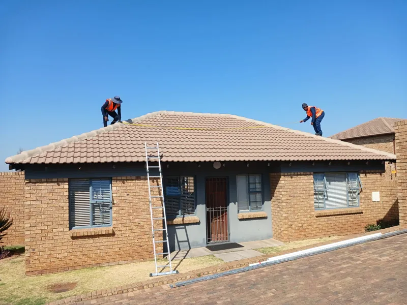 Installers fitting solar panels on the roof of a Midrand home